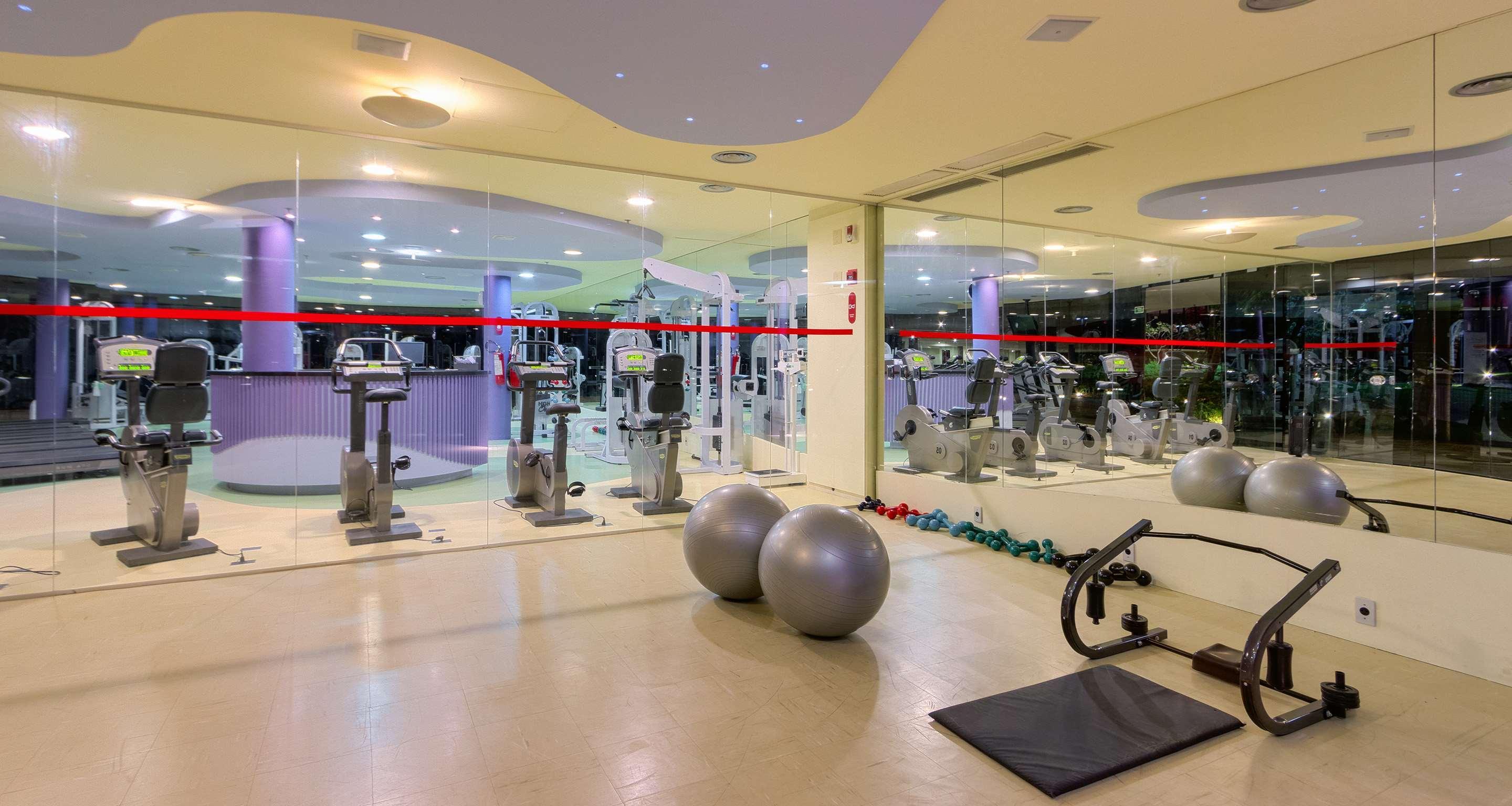 Royal Tulip Brasilia Alvorada Hotel Екстериор снимка The photo depicts a gym or fitness area. In the foreground, there are two large exercise balls and a mat on the floor. Behind them, there is a wall of mirrors that reflects various gym equipment, including exercise machines and bikes. The lighting in